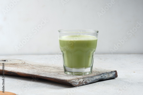 a glass of Japanese matcha latte, green tea with milk or soy milk, 
whitw background photo