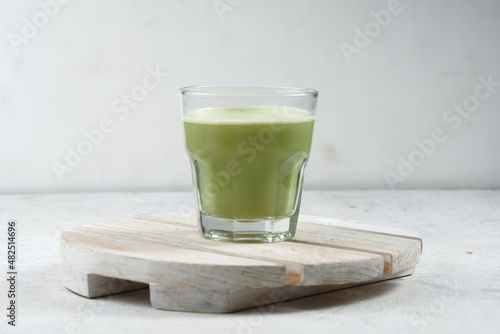 a glass of Japanese matcha latte, green tea with milk or soy milk, whitw background
