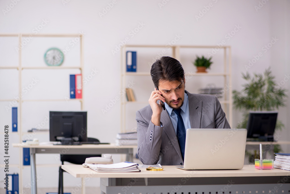 Young male employee working in the office Young male employee working in the office