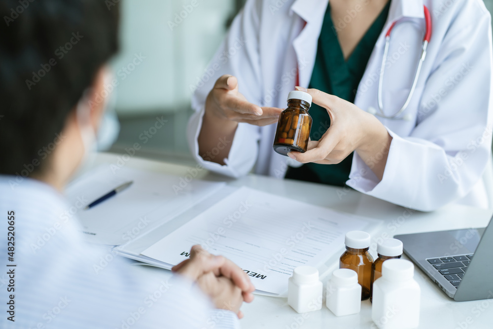 Female doctor hand holding bottle with pills and writing prescription. Healthcare, medical and pharmacy concept. Female doctor hand holding bottle with pills and writing prescription. Healthcare, medical and pharmacy concept.