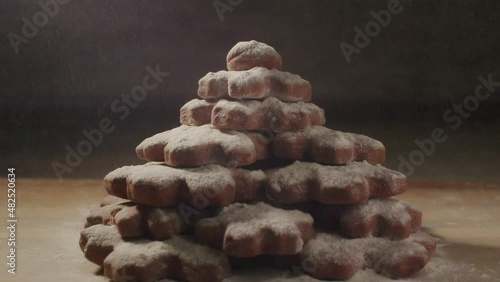 a large stack of cookies with flour blown away on a wooden table, close up static photo