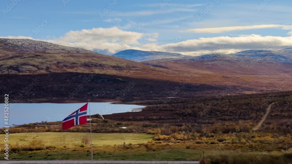 Norwegian flag waving in the mountains with a lake in the background. Norwegian flag waving in the mountains with a lake in the background.