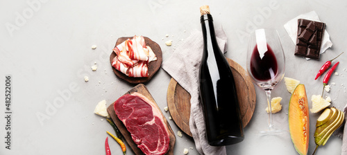 Red wine Primitivo with appetizers on gray background.