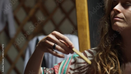 Beautiful woman in an ecovillage commune burns incense in a meditation ceremony