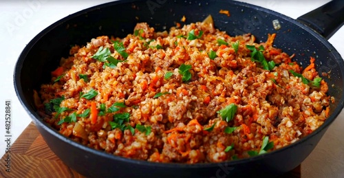 stewed buckwheat with minced meat and vegetables in a frying pan