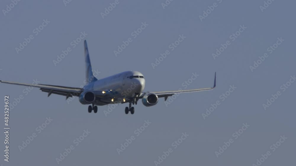 Bottom view, silhouette of a passenger jet aircraft approaching for landing against a cloudy gray sky. Tourism and aviation concept Bottom view, silhouette of a passenger jet aircraft approaching for landing against a cloudy gray sky. Tourism and aviation concept