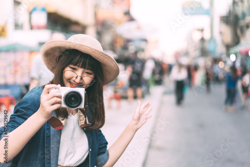 Young adult asian cute woman wear eyeglasses traveller backpack with camera solo local travel. © dodotone
