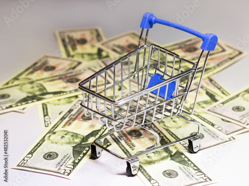 An empty shopping cart and money background