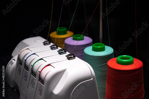 close-up Professional overlock sewing machine with multicolored thread photo