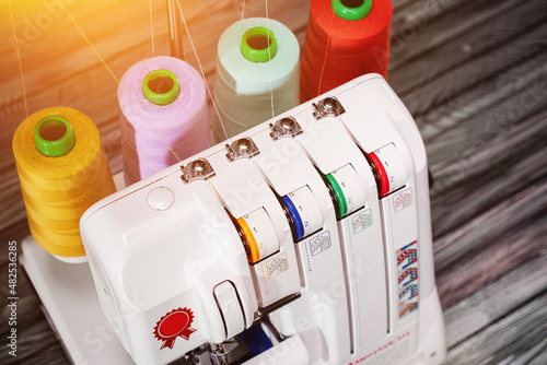 close-up Professional overlock sewing machine with multicolored thread photo