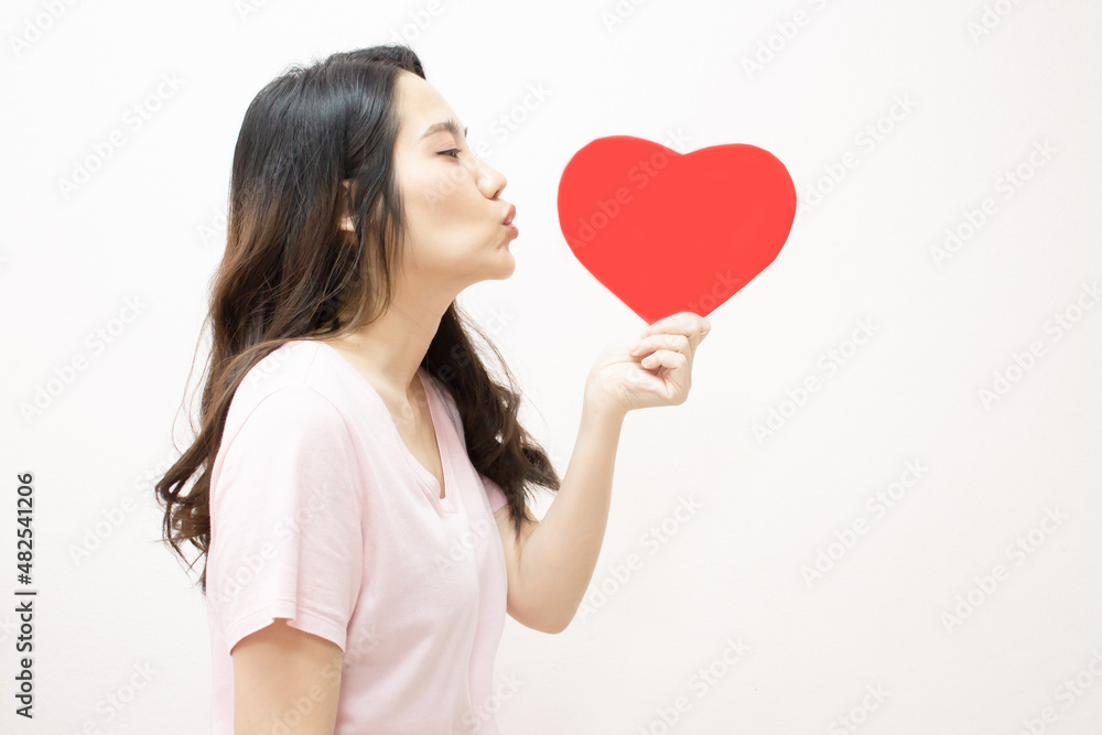 Asian beautiful woman are holding red heart shape paper and do blow kiss with happiness. A Valentine day and Love. Asian beautiful woman are holding red heart shape paper and do blow kiss with happiness. A Valentine day and Love.