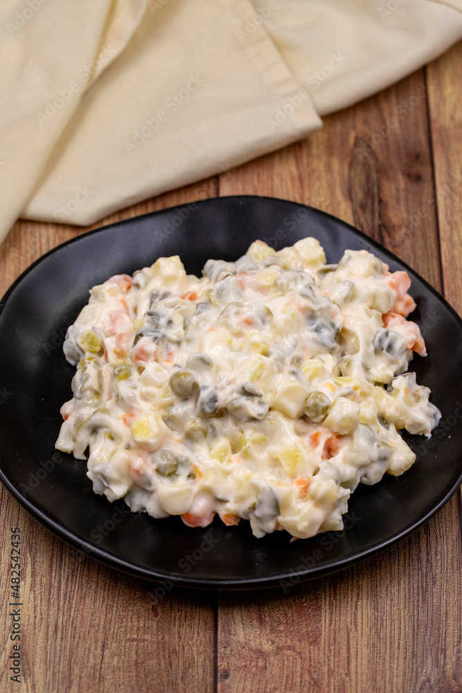 Potato salad with mayonnaise. Traditional salad with cooked vegetables with mayonnaise. Russian salad