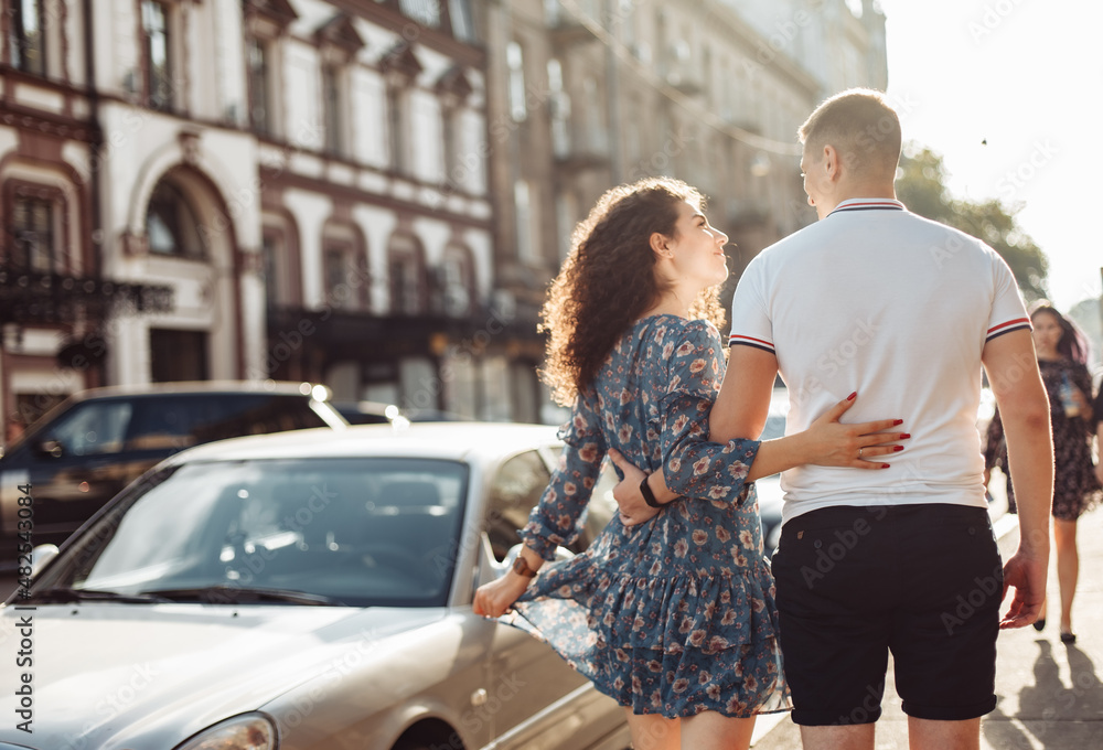 Young couple in love is walking in the city at sunset. Romantic date. Falling in love concept Young couple in love is walking in the city at sunset. Romantic date. Falling in love concept