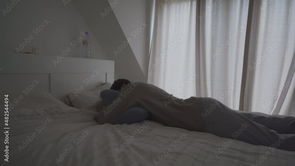 Man jumping onto a warm, comfortable bed, grabbing pillows and falling fast asleep Man jumping onto a warm, comfortable bed, grabbing pillows and falling fast asleep
