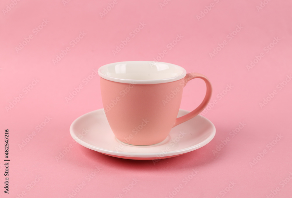 Empty ceramic cup and saucer on pink background Empty ceramic cup and saucer on pink background