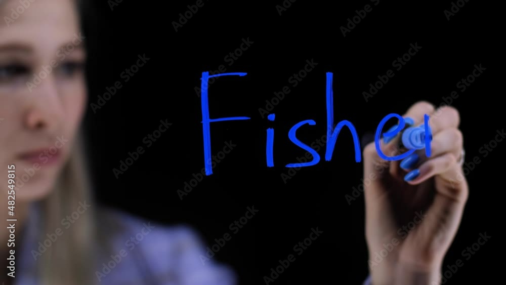 The girl writes the word fisherman on a transparent board. The girl writes the word fisherman on a transparent board.