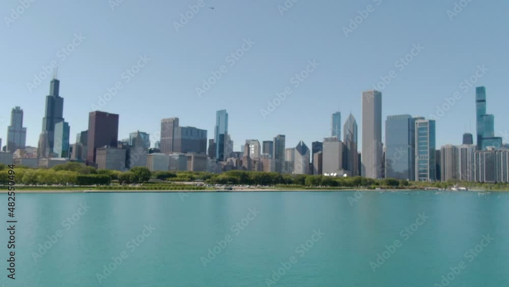 Aerial flying toward the downtown Chicago skyline over the turquoise waters of Lake Michigan. Aerial flying toward the downtown Chicago skyline over the turquoise waters of Lake Michigan.