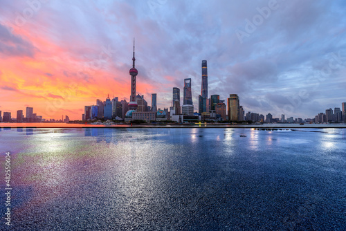 Empty asphalt road and city skyline with modern commercial buildings in Shanghai, China.