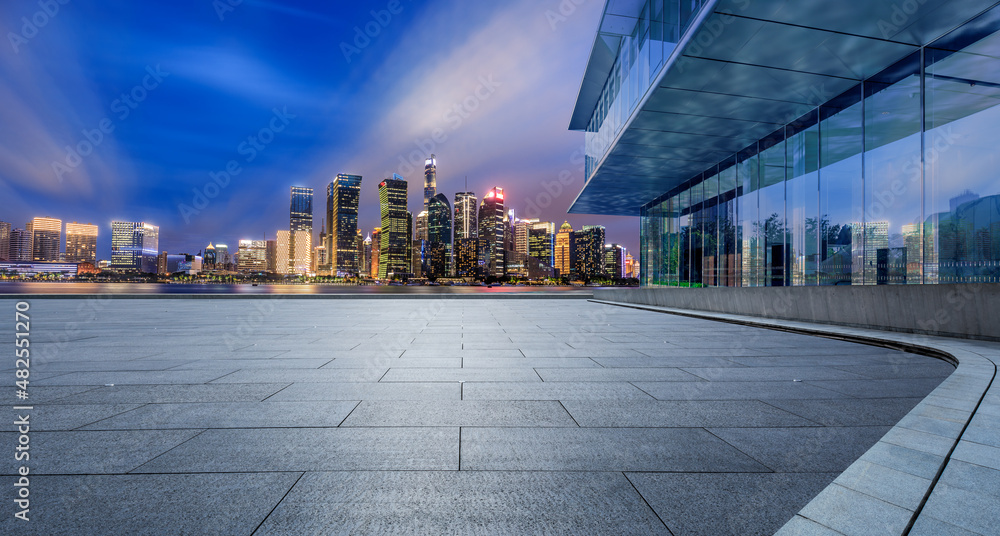 Panoramic skyline and modern commercial office buildings with empty square floor in Shanghai at night, China. empty road and cityscape.