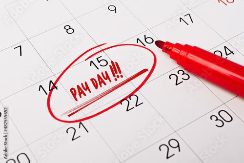 text - Pay day ritten on calendar for remind. Closeup of a personal agenda. Business, finance, savings money, wages, payroll or accounting concept