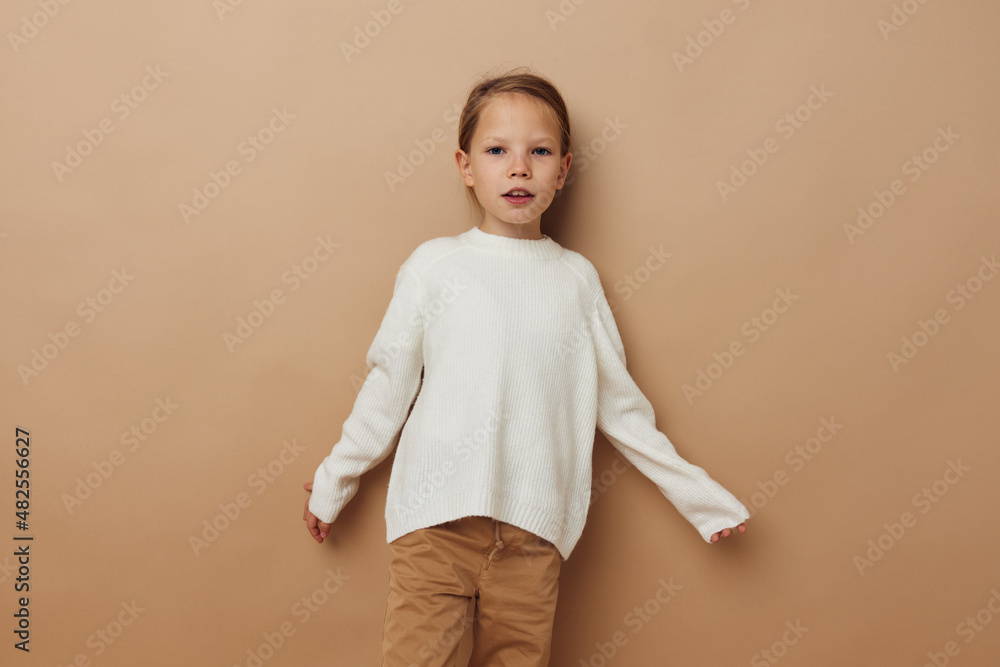 Portrait of happy smiling child girl in white sweater posing hand gestures childhood unaltered