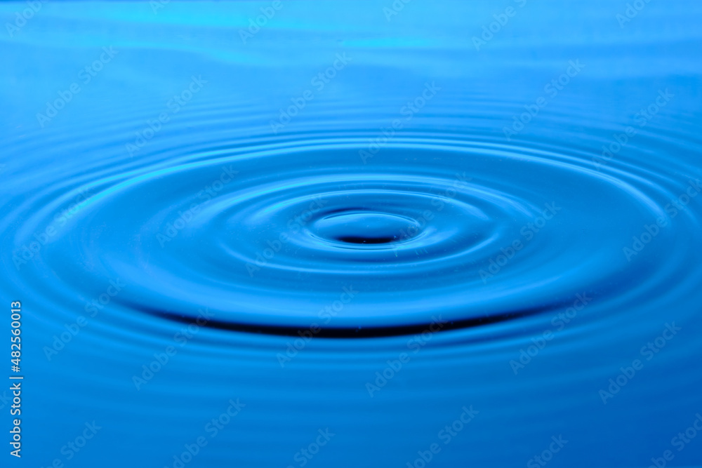 Bright blue background with diverging circles from dropped drop on surface water. Bright blue background with diverging circles from dropped drop on surface water.