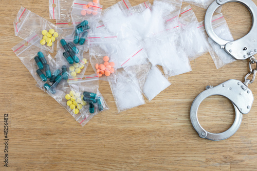 On the table lie bagged loose and toilet drugs and handcuffs.