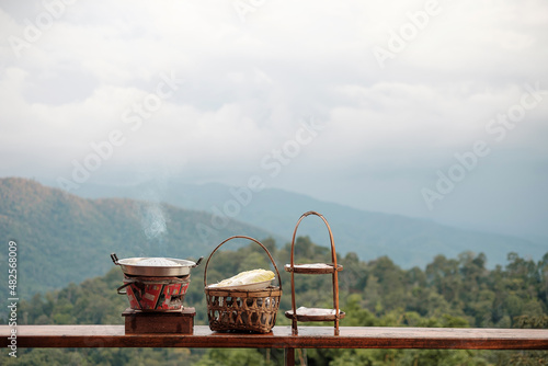 Pork or meat with vegetables and soup on the hot pan against mountain view background, Traditional Thai BBQ style is famous in Thailand photo