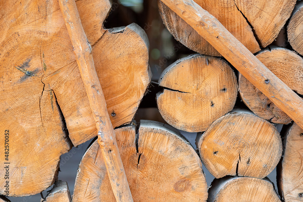 Wallpaper made of natural brown wood. Logs lying on top of each other. A lot of wood materials. Background with a tree texture. Dry chopped firewood. Log wall. Wallpaper made of natural brown wood. Logs lying on top of each other. A lot of wood materials. Background with a tree texture. Dry chopped firewood. Log wall.
