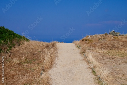 Dirt trail through dry landscape in Cap Corse. Corsica, France.