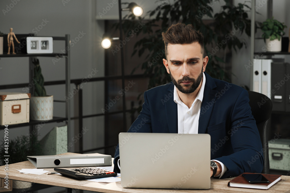 Man working on laptop at table in office, space for text Man working on laptop at table in office, space for text