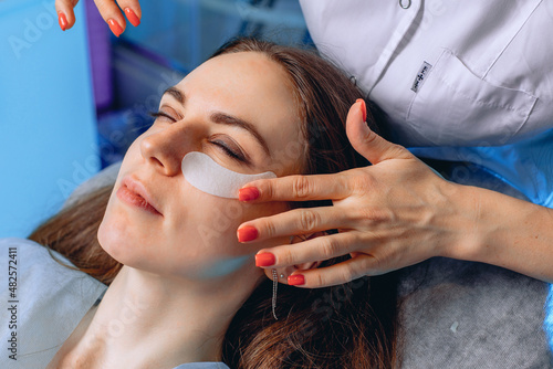 Reduction of bags under the eyes due to patches. A cosmetologist conducts a facial skin care procedure.