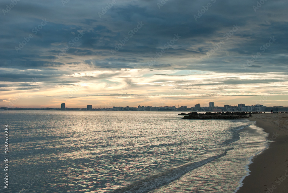 Lanscape with sand beach, quay and calm sea waters at cloudy sunset Lanscape with sand beach, quay and calm sea waters at cloudy sunset