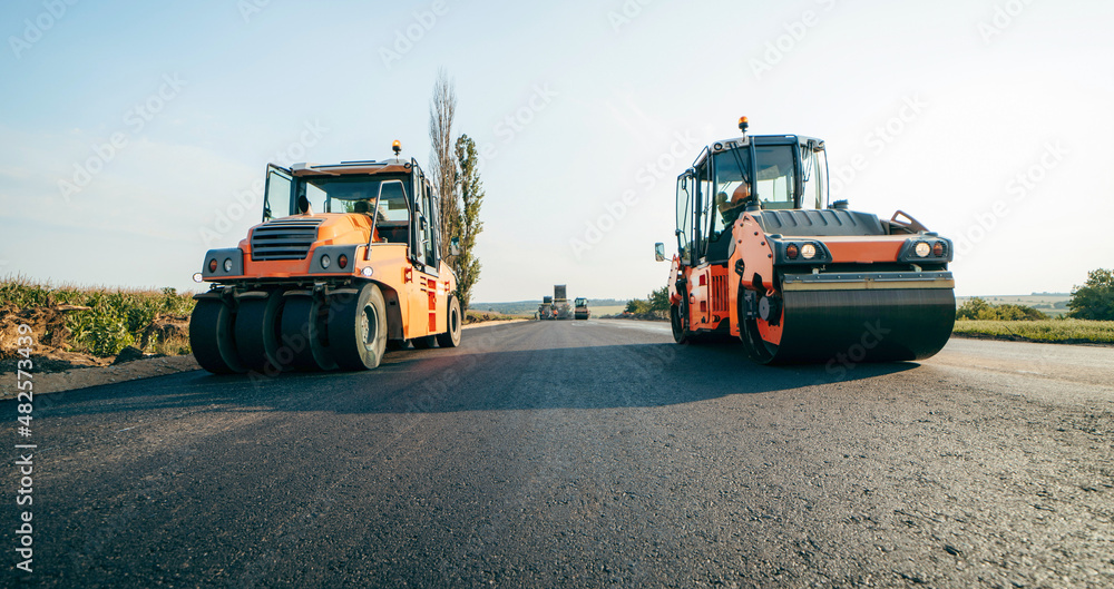 Vibratory asphalt roller compactor compacting new asphalt pavement. Road service repairs the highway Vibratory asphalt roller compactor compacting new asphalt pavement. Road service repairs the highway