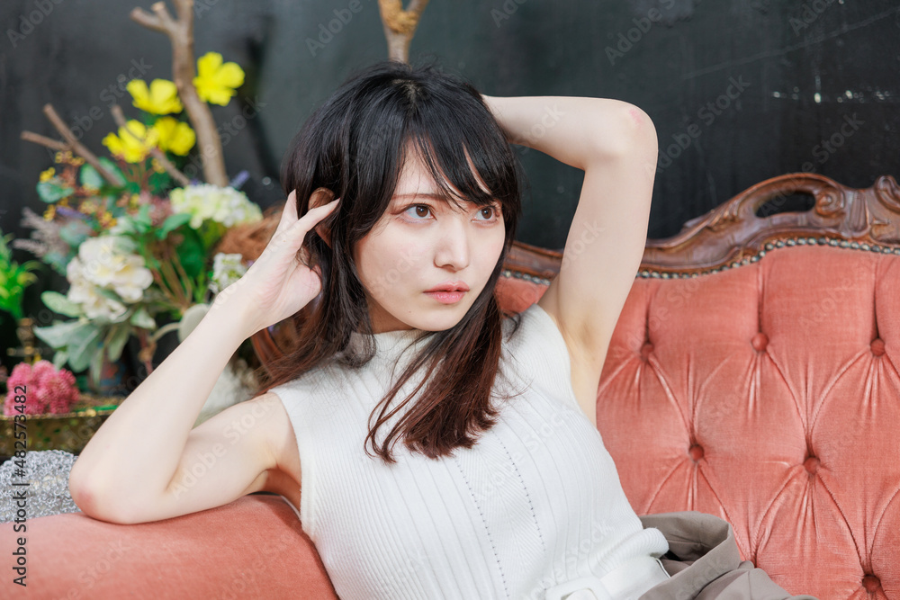 豪華な椅子に座るアジア人女性と薔薇の花瓶 Stock Photo Adobe Stock