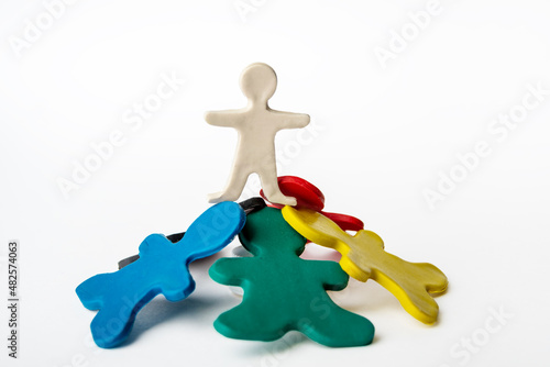A plasticine man standing on top of other plasticine men. Leadership concept. Conceptual image of teamwork on white