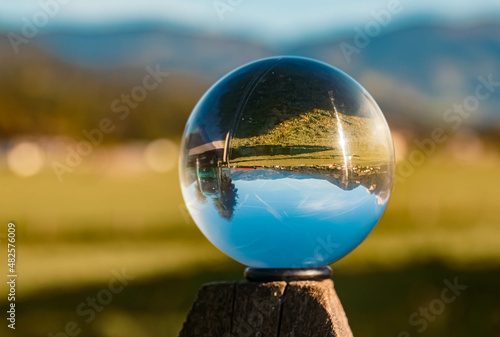 Crystal ball alpine summer landscape shot on a wooden pole near Saalfelden am Steinernen Meer  Salzburg  Austria