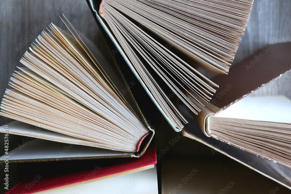 Fototapeta premium Bunch of vintage hardcover books on wooden background. Top view.