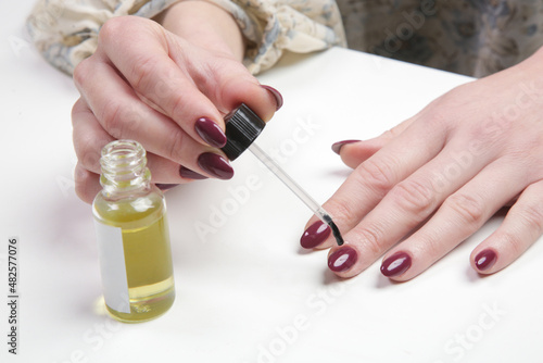 Woman applying cuticle oil on the nails. Hand skin care at home with moisturizing oil. Beauty  style  makeup  fashion  lifestyle concept.