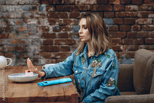 Tableau sur toile Lovely attractive sexual dieter woman in a cozy cafe says no to sweet cake