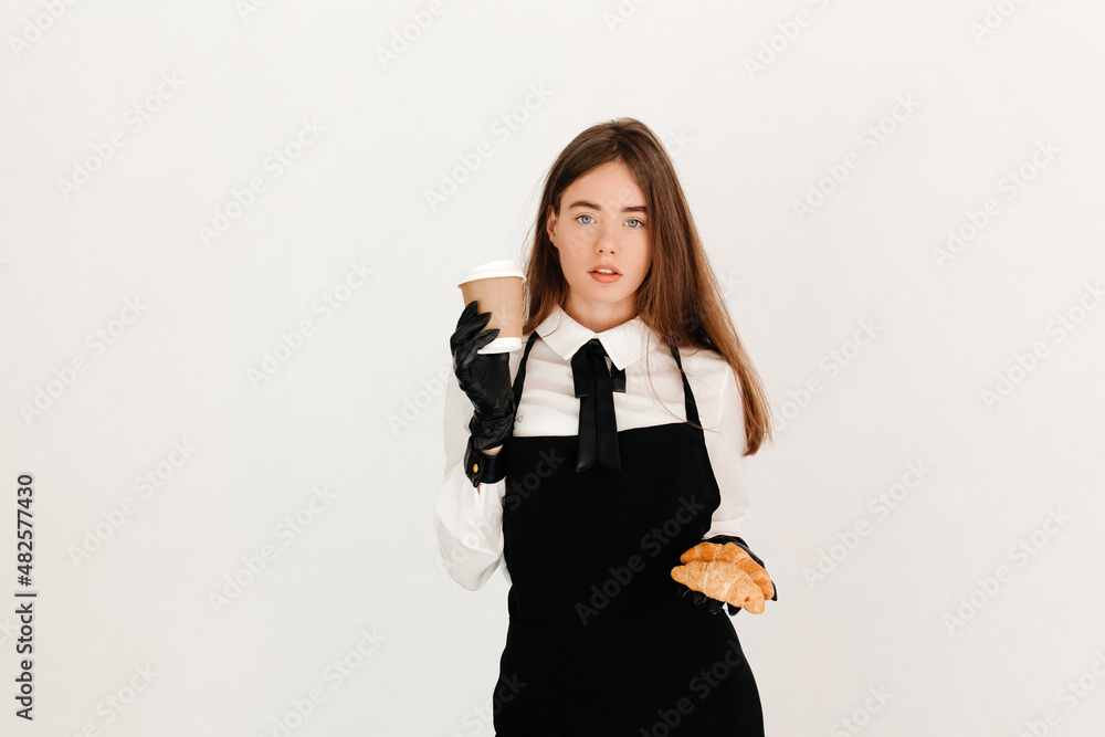 Serious waitress in work uniform serving takeaway coffee and a pair of croissants to a customer. Perfect service concept Serious waitress in work uniform serving takeaway coffee and a pair of croissants to a customer. Perfect service concept