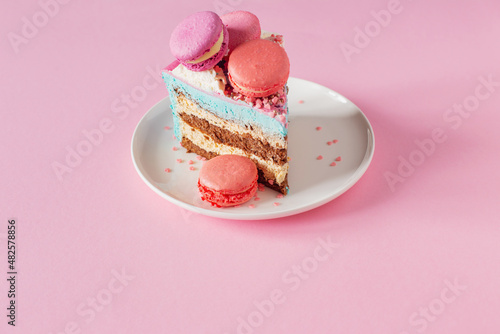 piece of cake with pink and blue decor on white plate on pink background