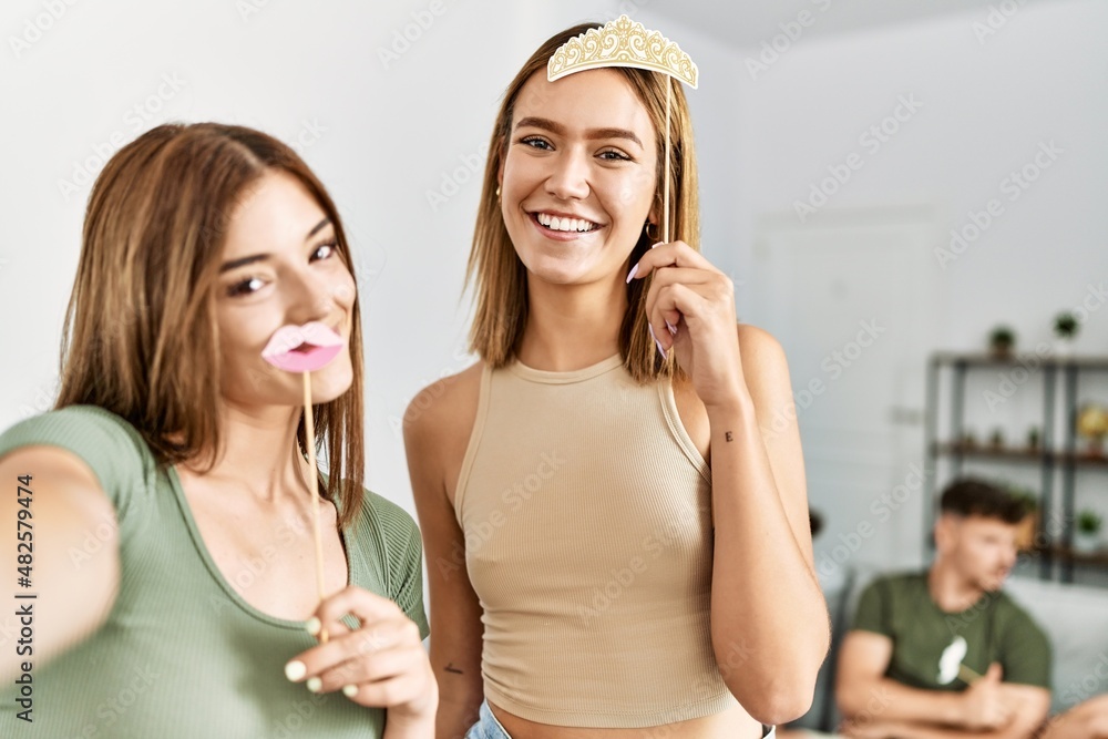 Two women on party smiling happy make selfie by the camera at home. Two women on party smiling happy make selfie by the camera at home.