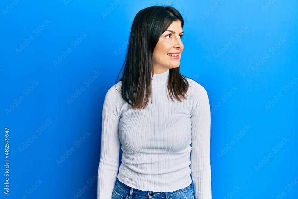 Young hispanic woman wearing casual clothes looking to side, relax profile pose with natural face and confident smile. Young hispanic woman wearing casual clothes looking to side, relax profile pose with natural face and confident smile.