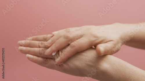 Wallpaper Mural Woman applying cosmetic moisturizing hand cream. Cosmetic products, green leaves on white table. Spa, manicure, skin care concept Torontodigital.ca