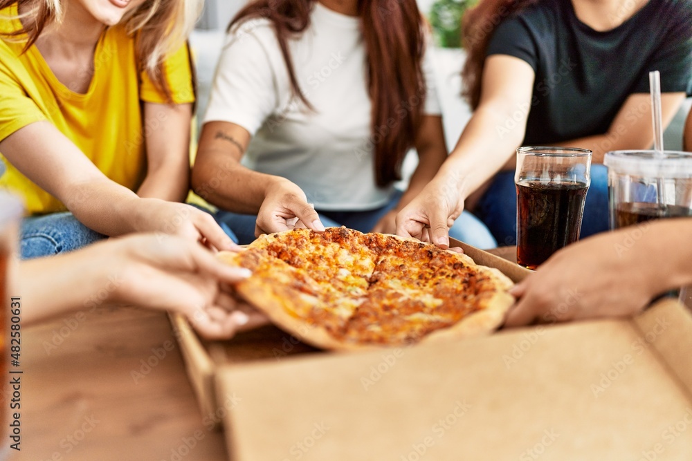 Group of woman holding portion of pizza at home. Group of woman holding portion of pizza at home.