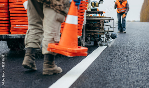 Workers applying new road markings, outside the city