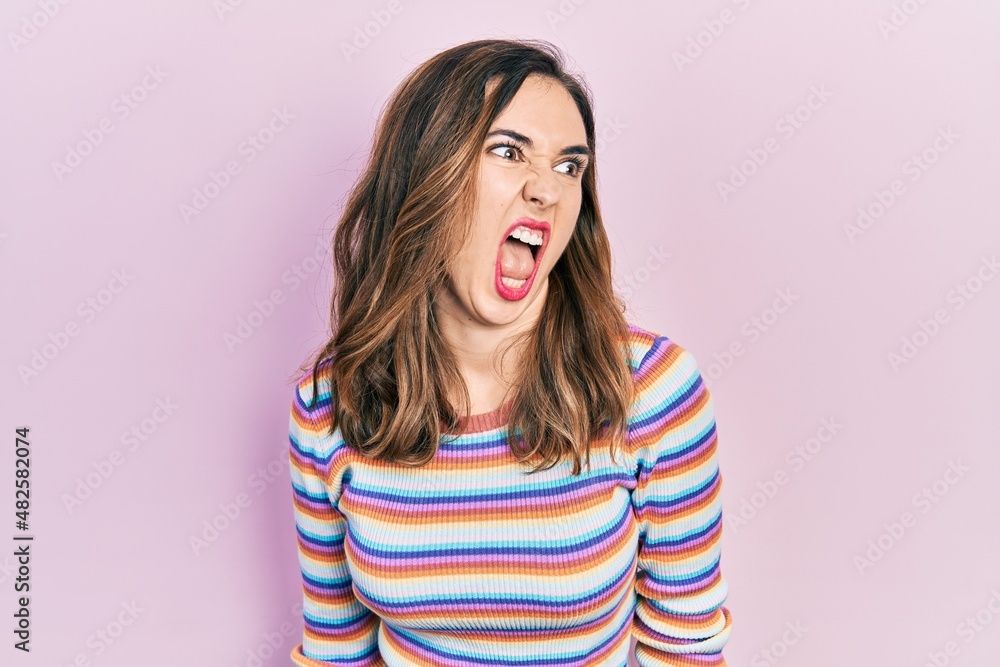 Young hispanic girl wearing casual clothes angry and mad screaming frustrated and furious, shouting with anger. rage and aggressive concept. Young hispanic girl wearing casual clothes angry and mad screaming frustrated and furious, shouting with anger. rage and aggressive concept.
