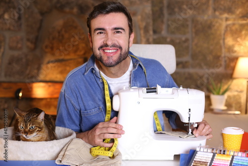 Young man using sewing machine photo