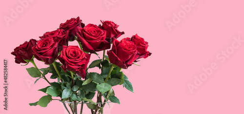 Fototapeta Naklejka Na Ścianę i Meble -  Bouquet of red roses in vase against pink background. Valentines day gift.